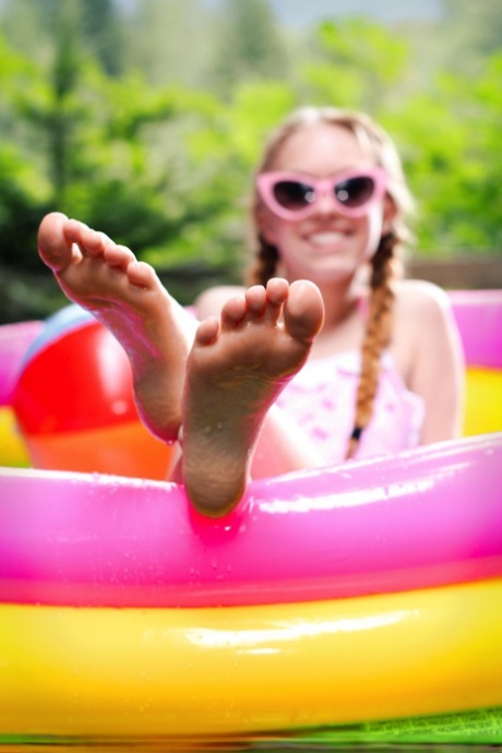 Очаровательная молоденькая Долли Литтл дергает себя за заплетенные косички в надувном бассейне 2