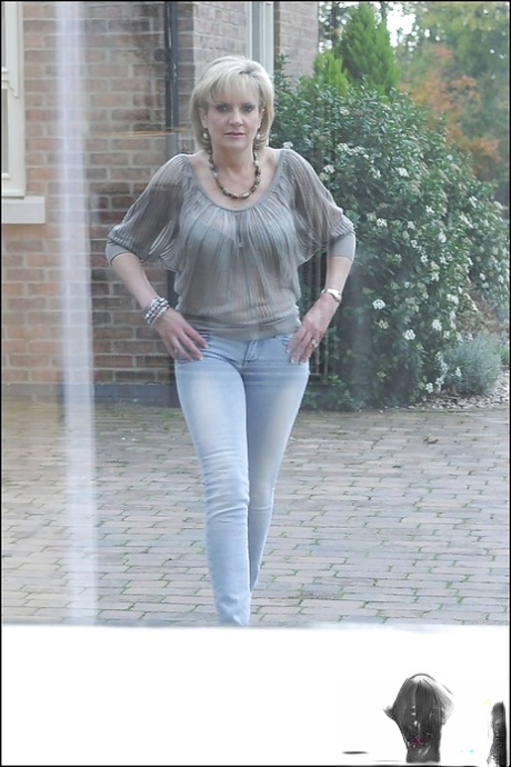 Противная зрелая мегера обнажает свои сиськи и приспускает синие джинсы 2