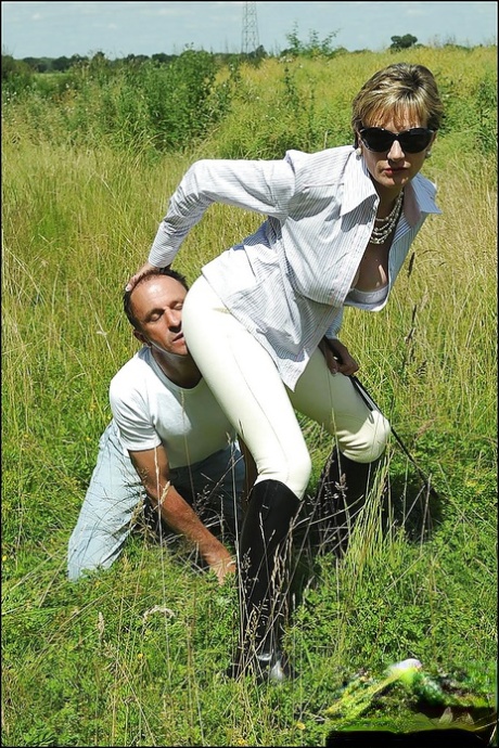 Грудастая зрелая фемдом в солнцезащитных очках мучает своего мальчика-раба на открытом воздухе 3