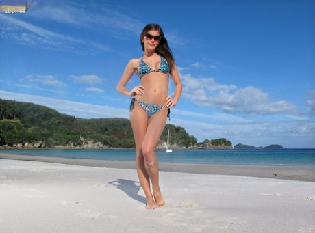 Сексуальная брюнетка Каприс снимает бикини, чтобы выставить напоказ красивые сиськи и раздвинутые ноги на пляже 1