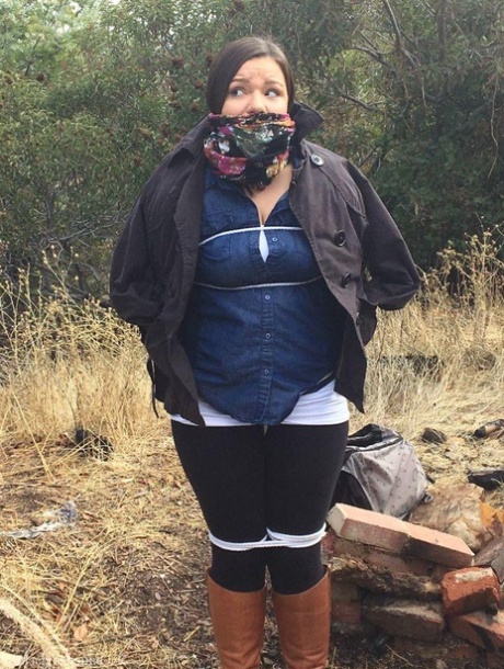 Полностью одетый толстяк расколот, с кляпом во рту и связанный веревкой в заросшем кустарником лесу 3