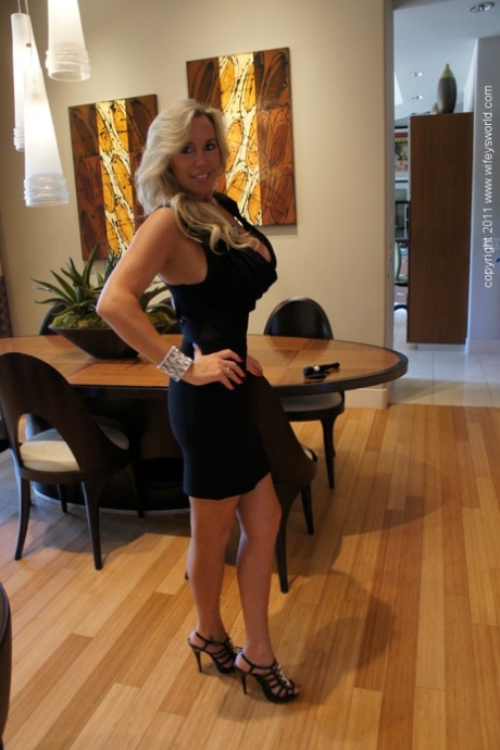 Великолепная блондинка на высоких каблуках обнажает свои большие сиськи и киску 5